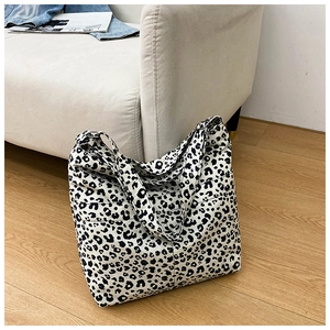 Detail of a large canvas tote bag with black and white leopard print on a cozy sofa