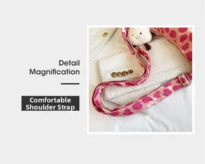 Détail d'une bandoulière réglable à motif léopard rose avec un porte-clé en peluche