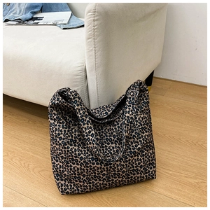 Close-up of leopard print canvas tote bag with adjustable metal buckle and wide strap
