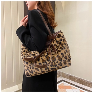 Woman in black blazer carrying leopard print faux fur tote bag with brown leather handles