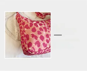 Gros plan du tissu en toile imprimé léopard rose montrant la texture fine et les motifs