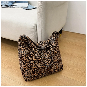 Detail of adjustable metal buckle and leopard print canvas texture on large tote bag