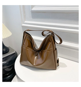 Detail of a dark brown large capacity faux leather tote bag on a white display stand