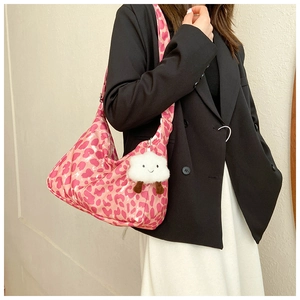 Gros plan sur un sac à bandoulière léopard rose avec pendentif nuage en peluche blanc