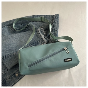 Détail du sac bandoulière en nylon vert menthe avec fermeture éclair et logo
