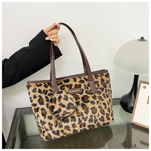 Close-up of leopard print faux fur tote bag with matching round coin purse and leather handle