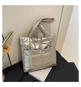 Detail of champagne gold quilted tote bag with metallic finish on decorative books