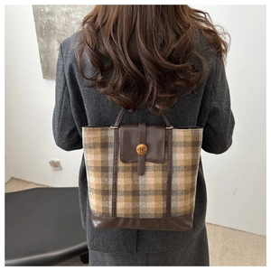 Detail of vintage plaid woolen tote bag featuring a leather buckle and gold N button