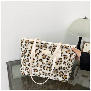 Close-up of leopard faux fur tote with a matching coin purse and golden brand plaque