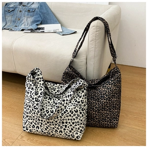 Detailed view of large leopard print canvas tote bags in black and brown animal patterns