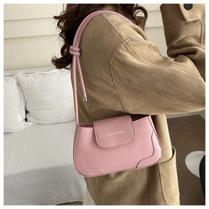 Detail of pink shoulder bag with FASHION & BAGS text and minimalist knotted strap design