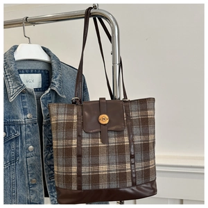 Detail of vintage plaid wool backpack with leather flap and metal N buckle accent