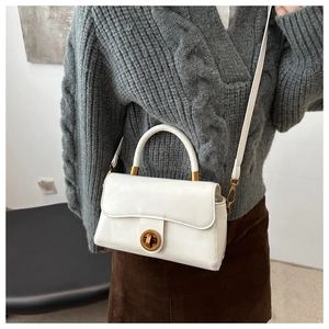 Détail du sac à bandoulière en cuir ciré blanc avec fermoir rotatif doré vintage