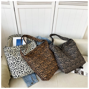 Detailed view of large leopard print tote bags in beige, yellow, and coffee brown canvas