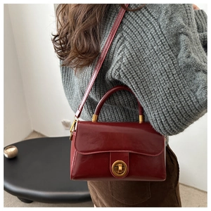 Détail d'un sac à main vintage en cuir ciré avec fermoir doré et bandoulière