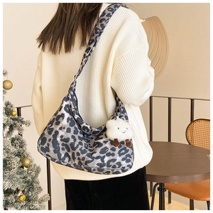 Sac hobo léopard avec breloque mouton porté avec un pull en maille torsadée beige