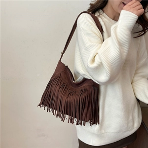 Brown faux suede fringe tote bag worn by model in minimalist knit sweater outfit