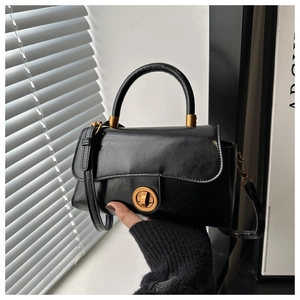 Détail du sac à main vintage en cuir ciré avec fermoir rotatif doré et poignée élégante