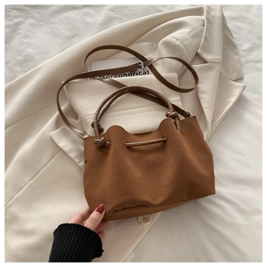 Detailed view of brown ruched bucket bag with soft suede texture and drawstring closure
