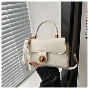 Vue détaillée du sac crème avec un fermoir rotatif doré et une texture de cuir raffinée