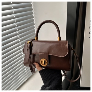 Détail d'un sac à main vintage en cuir ciré avec fermoir rotatif en métal doré