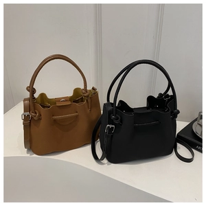 Detail view of stylish bucket bags with wavy edges in dark brown and black leather