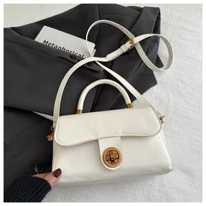 Détail du sac à main en cuir ciré blanc montrant le fermoir rotatif en métal doré