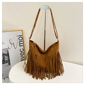 Detail view of brown suede shoulder bag with dense bohemian tassels and sturdy twin straps