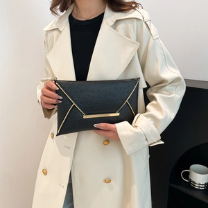 Elegant black envelope clutch bag with ostrich texture and gold metal trim