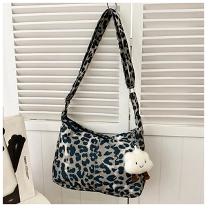 Détail du sac cabas léopard avec un pendentif nuage en peluche et bandoulière réglable