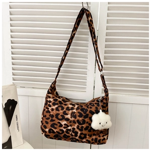 Détail d'un sac cabas léopard avec pendentif nuage en peluche et bandoulière réglable