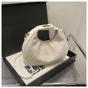 Detail of white crocodile embossed hobo bag with gold metal clasp and slim strap