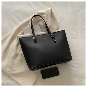 Détail du cabas noir en cuir Saffiano avec ferrures dorées et logo de la marque sur tissu