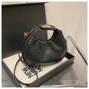 Detail of woven crescent bag with gold lock buckle and black leather shoulder strap