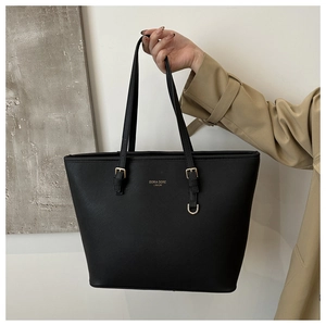 Détail du sac cabas en cuir noir avec lettrage doré et anneau décoratif en métal