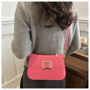 Detailed back view of pink quilted crossbody bag with golden buckle on female model