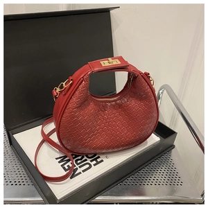 Detail of red crescent woven handbag with gold twist lock and fine leather texture