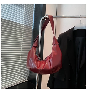 Macro detail of the wine red glossy patent leather with elegant cloud-like pleats