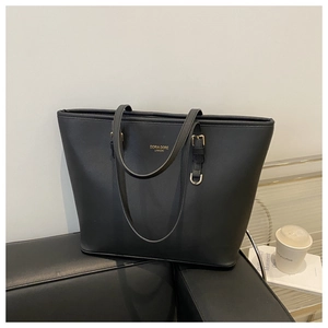 Détail du cabas en cuir Saffiano noir avec ferrures dorées et logo de la marque