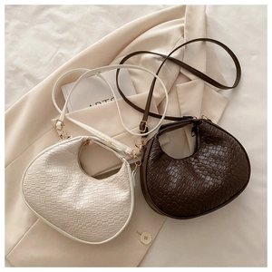 Close-up of woven texture and gold hardware on minimalist crescent shoulder bags
