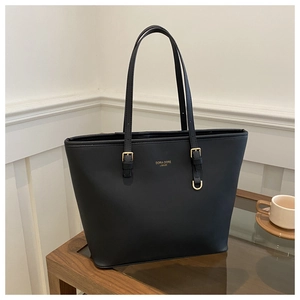 Détail du grand sac cabas noir avec logo doré et finitions métalliques de qualité