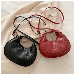 Detail shot of woven texture on crescent hobo bags in black and vintage red colors