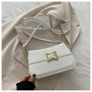 Close-up of white quilted crossbody bag with gold square buckle on a beige background