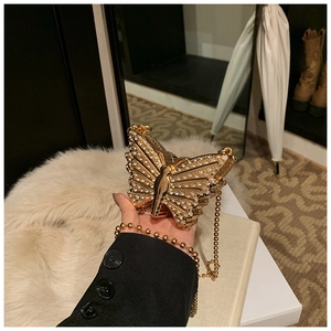Macro shot of sparkling crystal-encrusted butterfly evening bag with gold chain strap