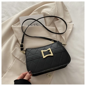 Detailed close-up of black quilted shoulder bag with a stylish gold geometric buckle