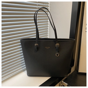 Detail view of black tote bag with gold Doria Dore London logo and metallic buckle strap