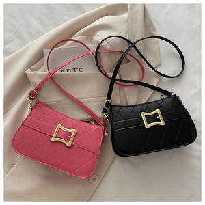 Détails de sacs matelassés rose et noir avec boucle dorée posés sur un blazer chic