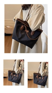 Detail of the large waterproof nylon tote with brown leather trim and top zipper closure