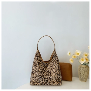 Detail view of large leopard print hobo bag with matching mini pouch on white surface