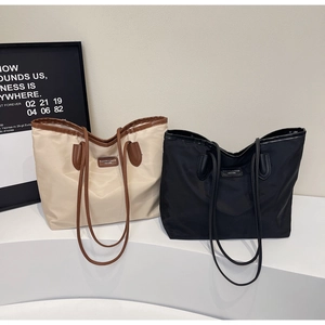 Close-up of waterproof nylon tote bags with premium faux leather trim and fashion label